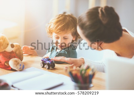 You make me happy. Delighted young thoughtful mother playing with her little child using toys and sitting at the table. Royalty-Free Stock Photo #578209219