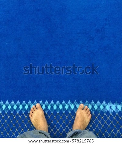 Foot of muslim people stand with blue carpet background