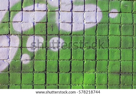 Painted mosaic brick tile wall, close up of graffiti texture, with vibrant colors for creativity, imaginative backgrounds and ideas. Grunge and urban.