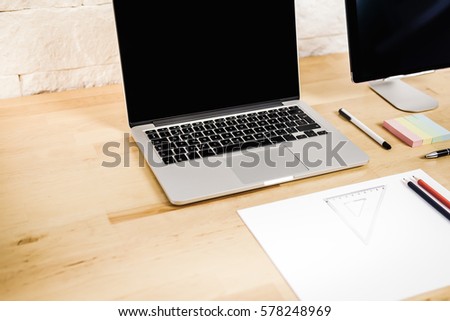 view on a wooden desk with a computer tablet and paper