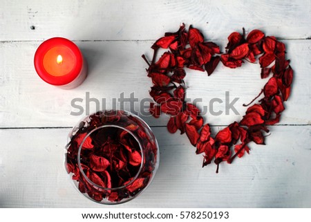 Valentine's day (14 February), International Women's Day (8 March), the day the mother and other holiday: Dry petals in the form of heart and a burning red candle