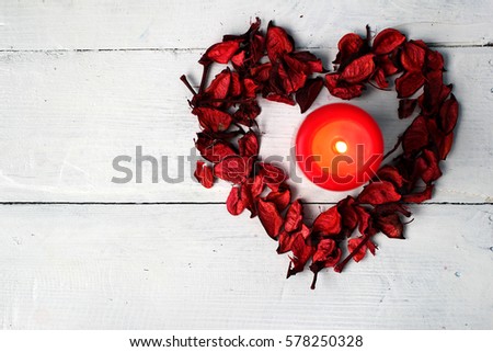 Valentine's day (14 February), International Women's Day (8 March), the day the mother and other holiday: Dry petals in the form of heart and a burning red candle