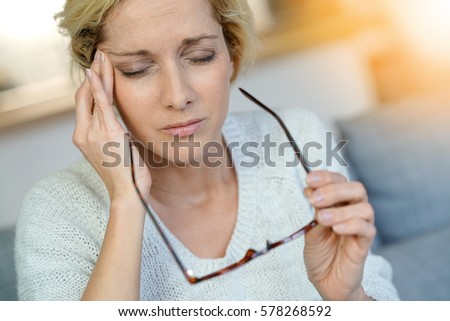 Portrait of middle-aged blond woman having a migraine Royalty-Free Stock Photo #578268592