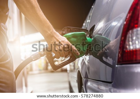 Grey car at gas station being filled with fuel on thailand Royalty-Free Stock Photo #578274880