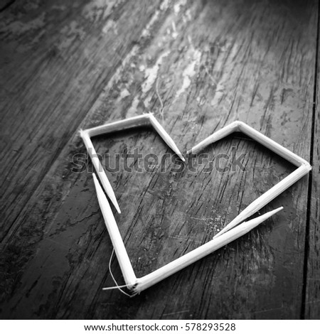 White heart on the black table , Heart make from 3 pieces of toothpick, big heart at the oblique view of picture