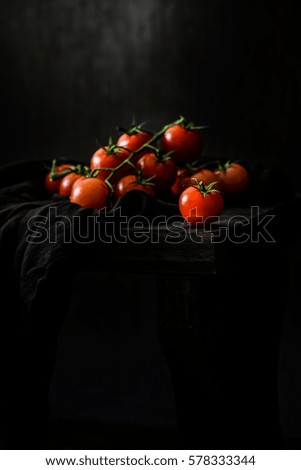 Cherry tomatoes on dark wooden background with copy space for text