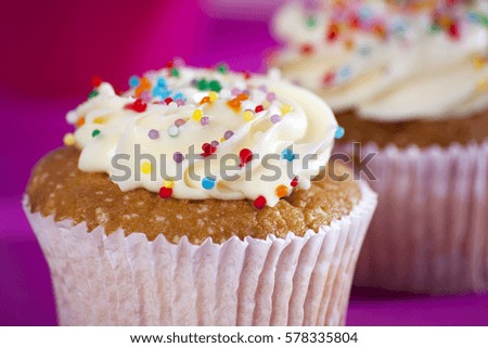 Cupcakes with white cream on the pink background, arranged for a party or a wedding reception