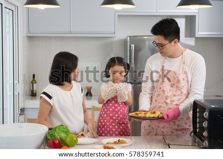 asian family enjoying and cooking pizza