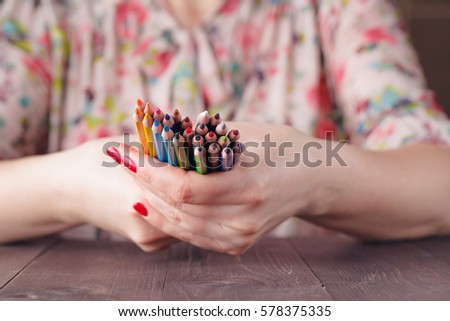 Bunch of colored pencil in woman hands, art design concept