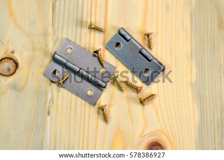 Two Pieces of Stainless Steel Door Hinges with screw On Wooden Background