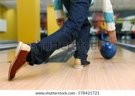 Unrecognizable man throw ball to bowling lane, closeup. Player plays active game, making strike. Cropped image of male leisure