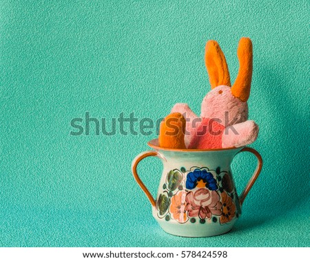Teddy rabbit on the turquoise background sitting on the  ceramic cream cup.