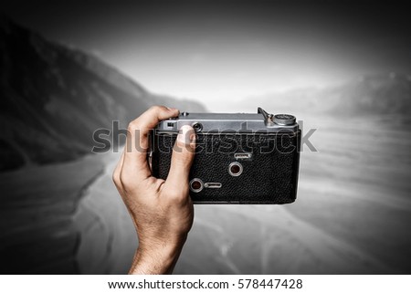Man taking photo with vintage camera . Mixed media
