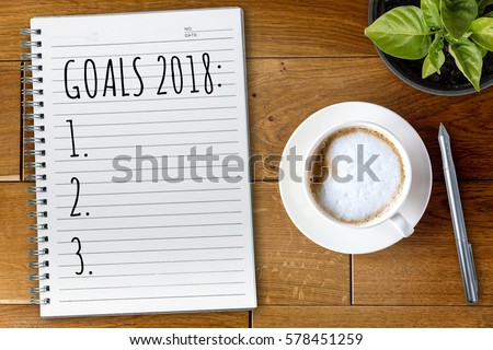 View from above on the table with a notebook and goals for 2018 year Royalty-Free Stock Photo #578451259