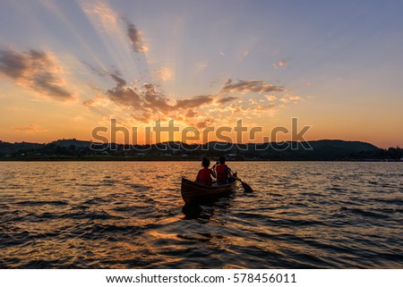 Unidentified traveler boating in the lake with sunlight