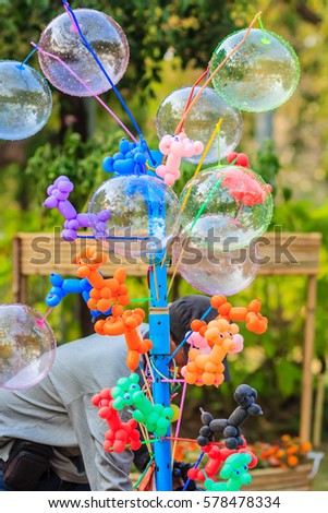 Unidentified street vendor selling cute dog balloons in Bangkok, Thailand.