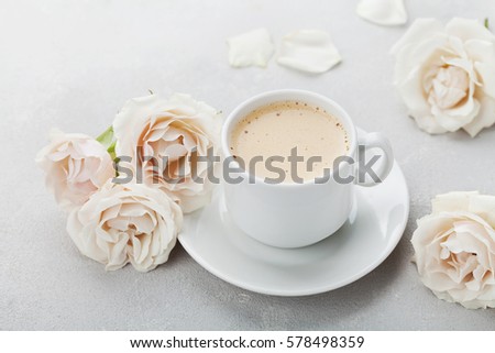 Coffee mug and vintage rose flowers for good morning on gray stone table. Beautiful breakfast on Mothers or Womans day