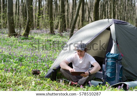 Backpacker uses a tablet outdoors.