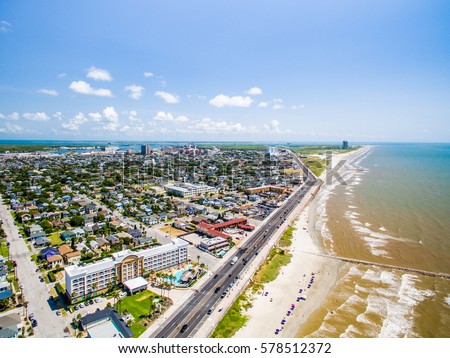 flying over Galveston Sea Wall and Beach  Royalty-Free Stock Photo #578512372