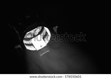 Classical spot light in metal body over black background, stage illumination equipment