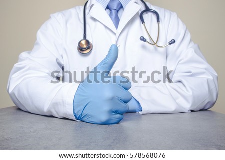 Doctor with stethoscope showing thumb up as sign of approval in blue latex glove.
