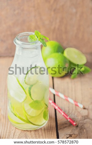 refreshing cucumber lemonade with lime and mint in a glass bottle