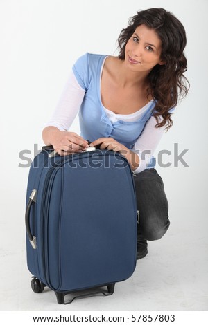 Woman closing her suitcase