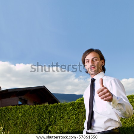 Young realtor in front of a house over blue sky.Young fresh model with longer hair.