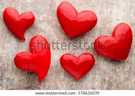 Hearts on the red color of the wood background.