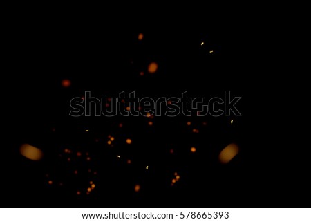 blurred sparks from fire in front of black backgound Royalty-Free Stock Photo #578665393