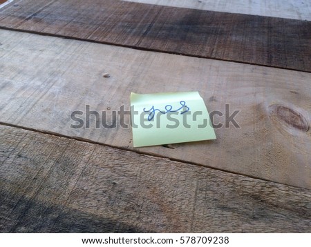 Yellow sticky note paper on the wooden table
