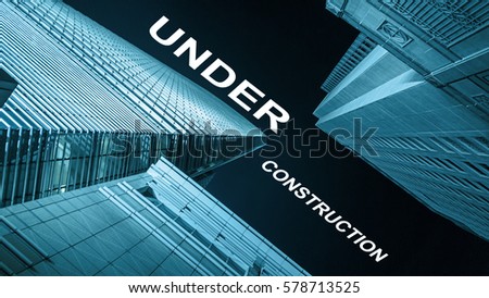 Modern buildings from low angle at night with text under construction.