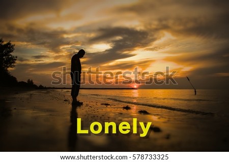 Creative conceptual,Lonely word on photo with silhouette man alone on the beach at sunset.Calm sea with rippling waves.