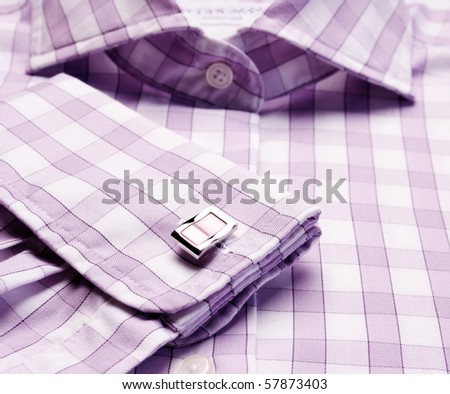 Close-up of cuff link on men's checkered shirt