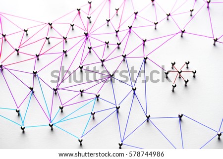 Linking entities. Networking, social media, SNS, internet communication abstract. Small network connected to a larger network. Web of light to dark blue, red, purple, gold wires on white background.  Royalty-Free Stock Photo #578744986