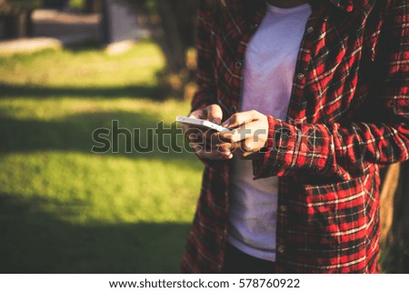Young woman using a smartphone outdoors at park.