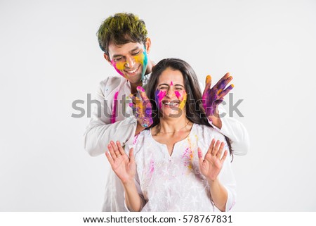 Indian Couple playing colours or people celebrating holi, isolated over white background