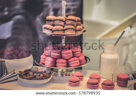 Blurred Background Fresh baked pink macaron pastry cookies in retail store display,