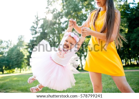mother with her baby on a walk. they are playing. they are having fun. laughing and smiling
