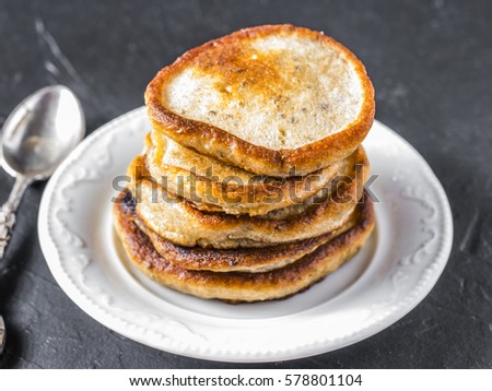 Stack of small pancakes with banana and chia seeds on black background. Pancake with chia or poppy seeds.