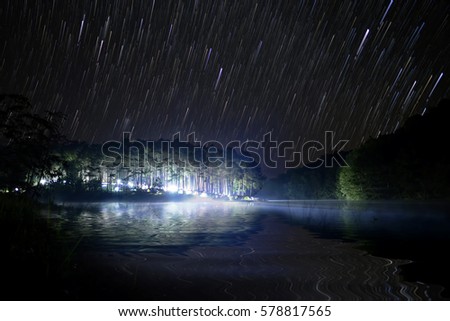 The " Star trails " and stars light night sky at Pang Ung lake, Pang Ung Mae Hong Son province, North of Thailand
