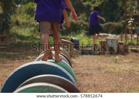 Kids playing in the playground. Running on tires.selective focus