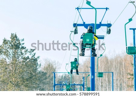 Snowboarder rises to the chairlift to the track.