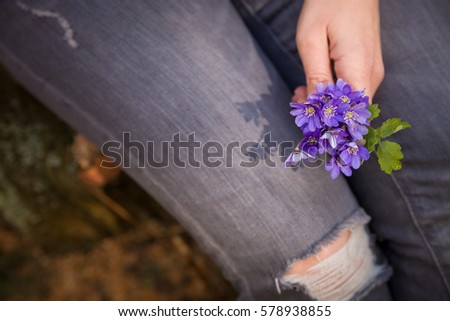 Woman holding beautiful snowdrop.  first spring flowers in a forest.  Wild flowers. spring concept.