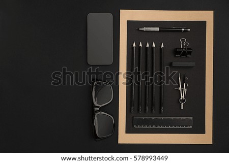 Office desktop with various black objects on  background