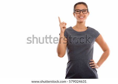 Studio shot of young beautiful businesswoman pointing finger up