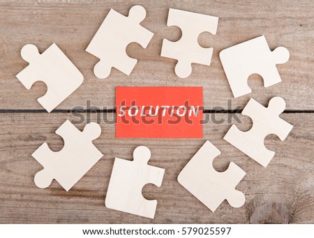 Business Teamwork Concept - Jigsaw Puzzle Pieces with text "Solution" on wooden background