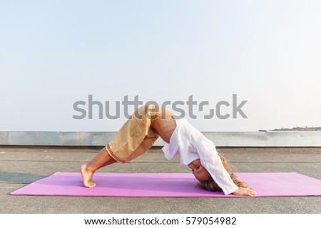 Baby doing yoga on the roof Royalty-Free Stock Photo #579054982