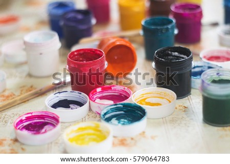 Set of gouache paints and watercolor for drawing, artistic tools on old wooden background. Tools for creative work. Concept of back to school and creative art. Top view.