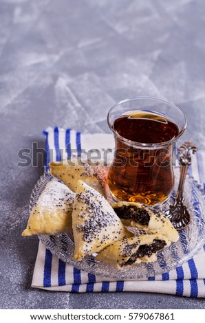 Triangular cookies with poppy seeds and powdered sugar. Selective focus.
